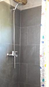 a shower with a shower head in a bathroom at Dharma in Punta Del Diablo +13 photos