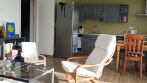 una cocina con 2 sillas blancas y una mesa en Ressourcez vous en pleine nature! en Saint-Régis-du-Coin