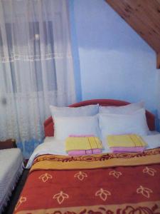 a bedroom with a bed with white pillows at Guesthouse Mijatovic in Žabljak