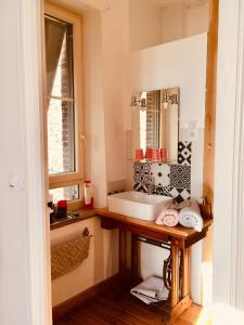 La salle de bains est pourvue d'un lavabo et d'un miroir. dans l'établissement Chambres d'hôtes Le 42, à Nogent-le-Rotrou