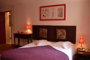 - une chambre avec un lit et une table avec deux lampes dans l'établissement Gîtes du Château de La Motte, à Usseau