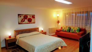 Un dormitorio con una cama y un sofá rojo. en Villa Sanitas, en Techirghiol