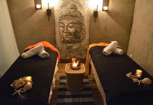um quarto com duas camas com velas e uma estátua em Lavand'Ange et SPA em Sarrians