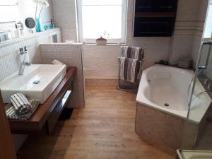 ein Badezimmer mit einer Badewanne, einem Waschbecken und einer Badewanne in der Unterkunft Ferienwohnung Drömmeljan in Xanten