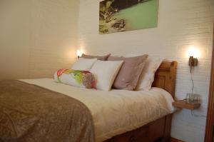 a bedroom with a bed with pillows on it at B&B BeZINspiratie in Schuinesloot