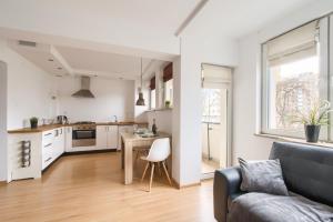 a kitchen and living room with a couch and a table at Labo Apartment Muranów in Warsaw