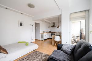 ein Wohnzimmer mit einem Sofa und einer Küche in der Unterkunft Labo Apartment Muranów in Warschau