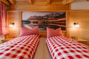 2 Betten in einem Zimmer mit einem Bild an der Wand in der Unterkunft Haus am Kramer in Garmisch-Partenkirchen