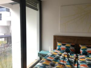 1 dormitorio con cama y ventana grande en Cosy Splendor / City Center en Graz