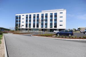 a blue van parked in front of a large building at Tananger Apartment Hotel in Tananger