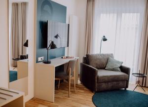 a living room with a chair and a desk at Hotel Jann von Norderney in Norderney