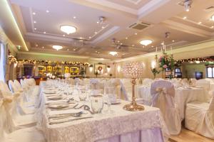 a banquet hall with white tables and white chairs at Flagstaff Lodge in Newry