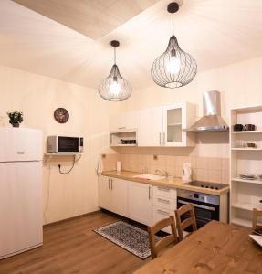 a kitchen with white cabinets and pendant lights at Live at TLV in Tel Aviv