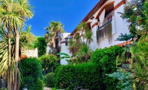 un edificio con palmeras y arbustos delante de él en Hotel Boutique America, en Miramar