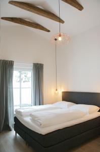 a bedroom with a large bed with white sheets at Mountainlodge by Skischule Hermann Maier in Flachau