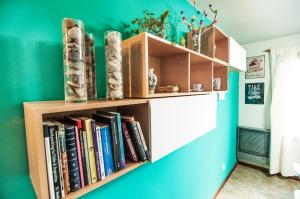 a book shelf filled with books on a blue wall at Casa Neneo Bariloche 2 in San Carlos de Bariloche
