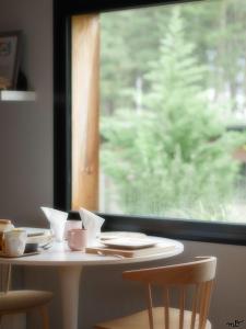 un tavolo con tazze e piatti e una finestra di la maison dans les bois a Oudon