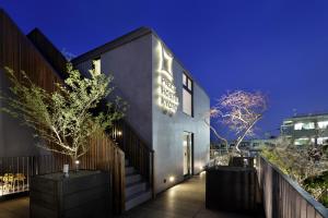 un bâtiment avec un panneau sur son côté dans l'établissement Piece Hostel Kyoto, à Kyoto