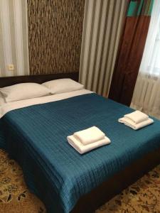 een bed met twee handdoeken erop bij Apartments Shuvar,Chervona Kalina in Lviv