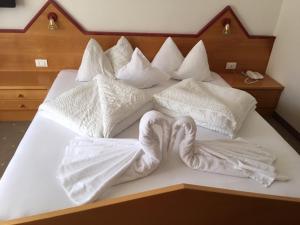 ナトゥルノにあるPension Nadineのベッド1台(タオルで作られた白鳥2羽付)