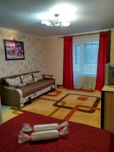 soggiorno con letto e tende rosse di Apartments near Arena on Syhivska a Lviv