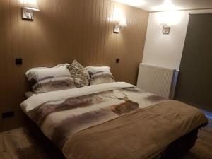 een slaapkamer met een groot bed met 2 kussens bij LA RIVIERE DU BIEN ETRE in Chaumont-Gistoux
