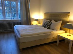 a bedroom with a bed with two lamps and two tables at Gestorfer Kötnerhof Business und Landlust in Springe