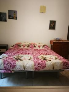 a bed in a bedroom with a pink blanket at Casa Teatro Greco in Catania