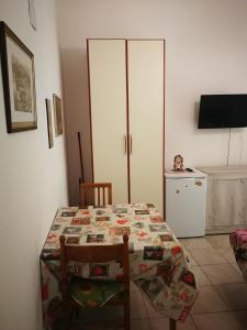 een keuken met een tafel en 2 stoelen en een keuken met een tv bij Casa Teatro Greco in Catania