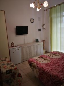a bedroom with two beds and a flat screen tv at Casa Teatro Greco in Catania