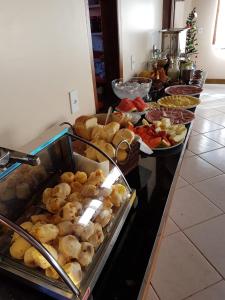 una línea de buffet con muchos tipos diferentes de comida en Villa Suzana, en Praia do Rosa
