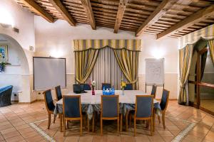 una sala conferenze con tavolo, sedie e schermo di Hotel Villa Luigi a Martinsicuro