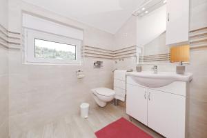 a white bathroom with a sink and a toilet at Vila Marijana in Preko +142 photos