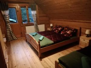 1 dormitorio con 1 cama en una cabaña de madera en Leśniczówka Przysietnica, en Przysietnica