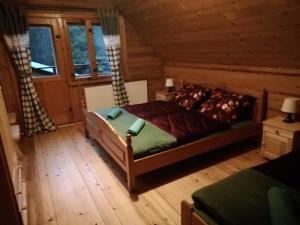a bedroom with a bed in a log cabin at Leśniczówka Przysietnica in Przysietnica