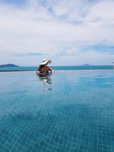 uma mulher de chapéu numa piscina em Espelho das Aguas Residence em Florianópolis