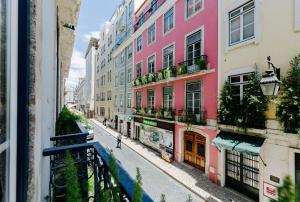 une personne marchant dans une rue avec des bâtiments dans l'établissement Lisbon Art Stay Apartments Baixa, à Lisbonne