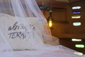 a wedding veil on a bed with a bottle of wine at Lo De Ro in Barra de Valizas