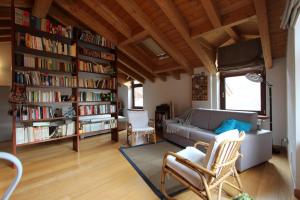 a living room with a couch and a book shelf at Casa Vacanze 'Lo Spirito Del Monte' in Capo di Ponte