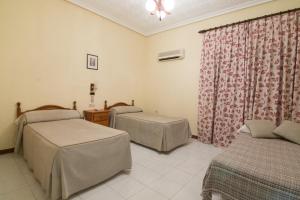 a hospital room with two beds and a window at Hostal Santa Ana in Madridejos