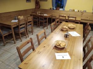 uma sala de jantar com mesas e cadeiras de madeira em Penzion Sněženka em Jiřetín pod Bukovou