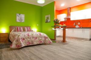 une chambre verte avec un lit et une cuisine dans l'établissement Casa Nunes, à Santana