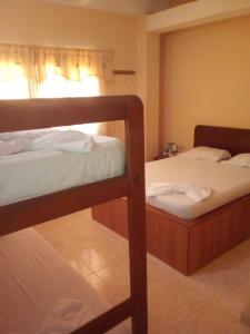 a bedroom with two bunk beds and a window at Hotel El Imperio in Santa Marta