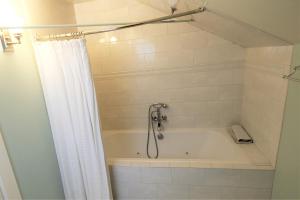 a bathroom with a bath tub with a shower curtain at Arroyo Vista Inn in Los Angeles