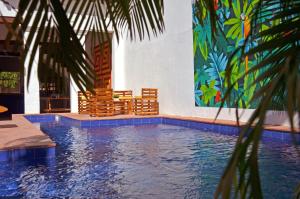 basen z krzesłami i obrazem na ścianie w obiekcie The Blue House Hostel w mieście Santa Marta