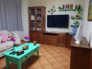 uma sala de estar com uma mesa de centro verde e uma televisão em Ajuy em Ajuy