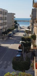 una calle vacía con coches aparcados en un lado de la playa en B&B Al Porticciolo, en Marsala