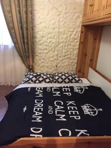 a bed with a black and white comforter on it at Apartament Basarab in Lviv