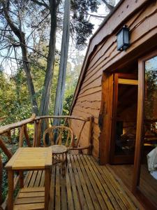 a wooden deck with a bench and a wooden cabin at Alpina Cabañas in Mar del Plata