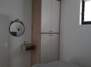 a bedroom with white cabinets and a mirror at Apartman D52 Dvori in Kopaonik